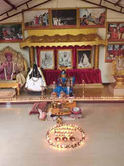 The deities of Ganesha, a Śiva Linga, and The SPH along with photos of Śri Ramakrishna, Sharada Devi, and Vivekananda